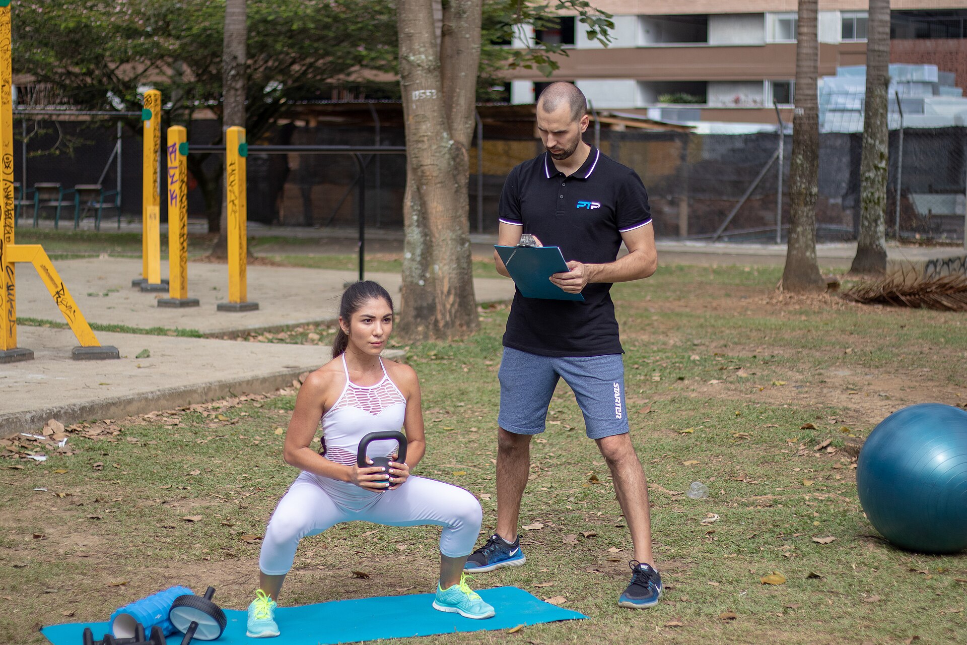 A coach watching a client's squat